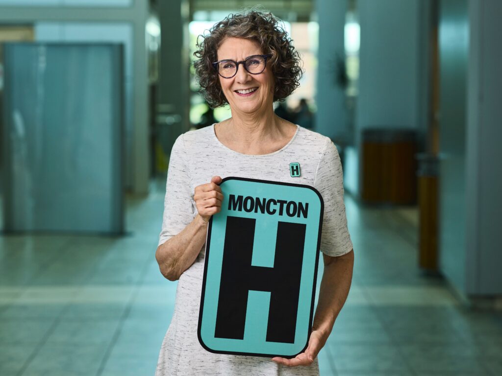 Celene  Holding H Sign and Smiling at camera