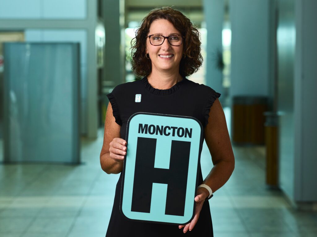 Christa Wheeler Thorne Holding H Sign and Smiling at camera