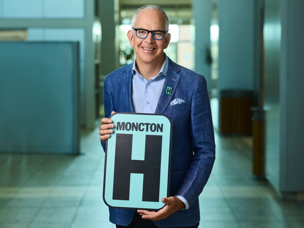 David  Holding H Sign and Smiling at camera