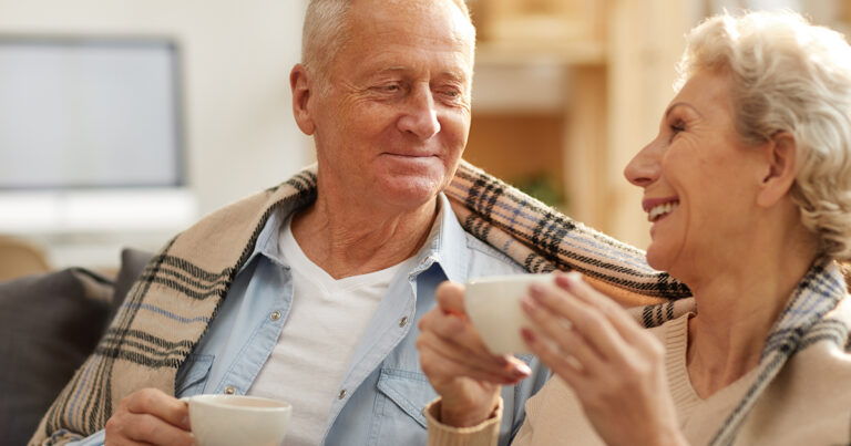 Couple de personnes âgées, souriant et prenant le thé