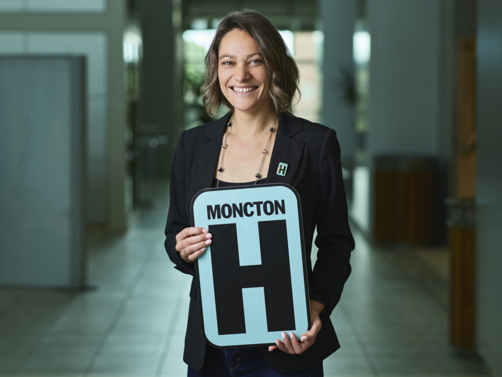 Jacqueline Stephen Holding H Sign and Smiling at camera