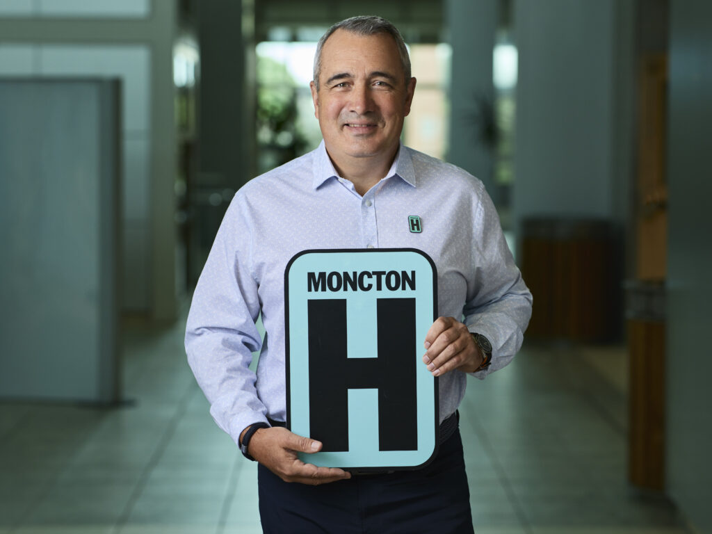 Mike Jenkins Holding H Sign and Smiling at camera