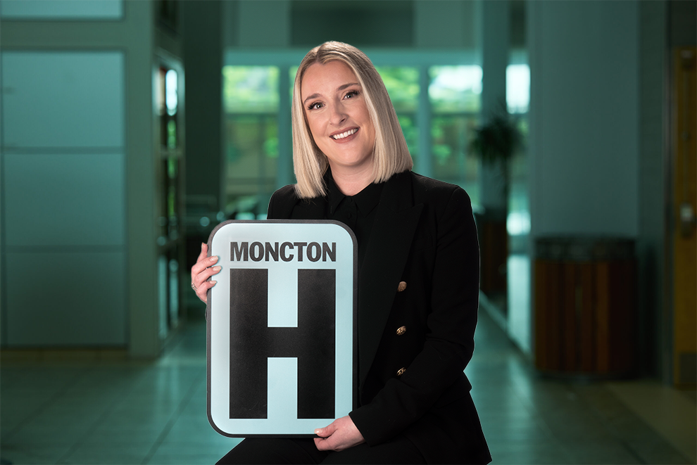 Marie-Pierre Robichaud tient une pancarte H et sourit à la caméra