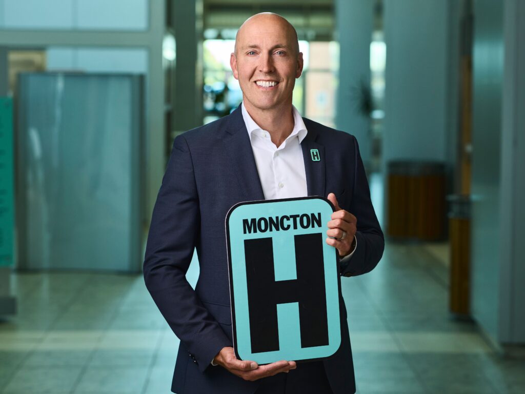 Ryan Dillon Holding H Sign and Smiling at camera