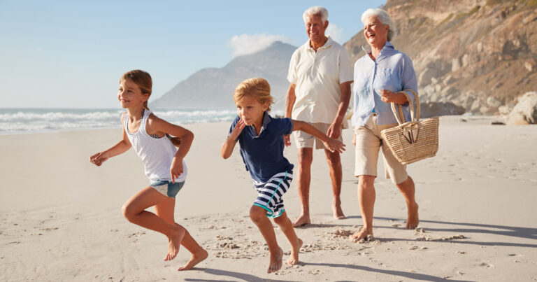 Grands-parents et petits-enfants marchant sur la plage