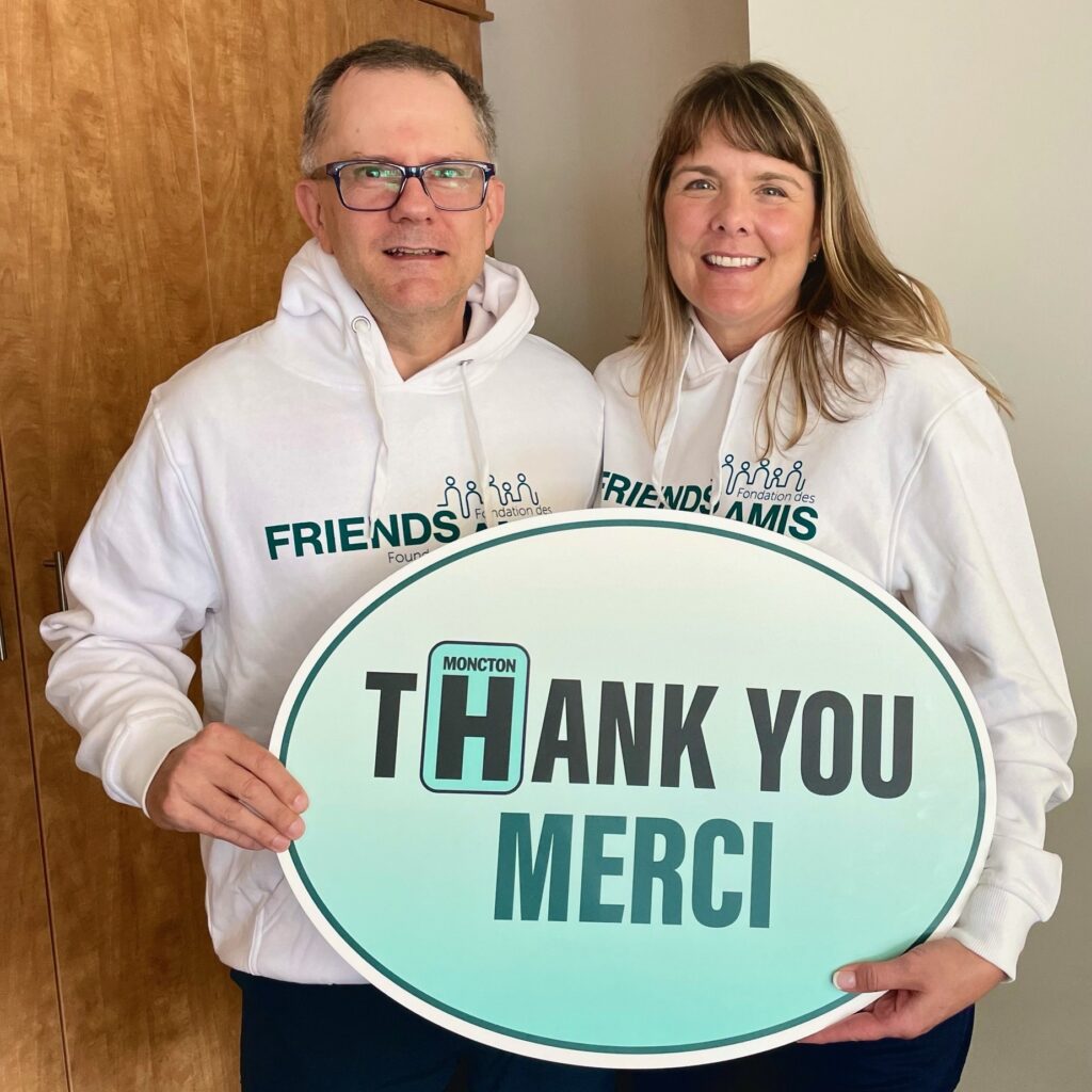 Two adults hold thank you sign