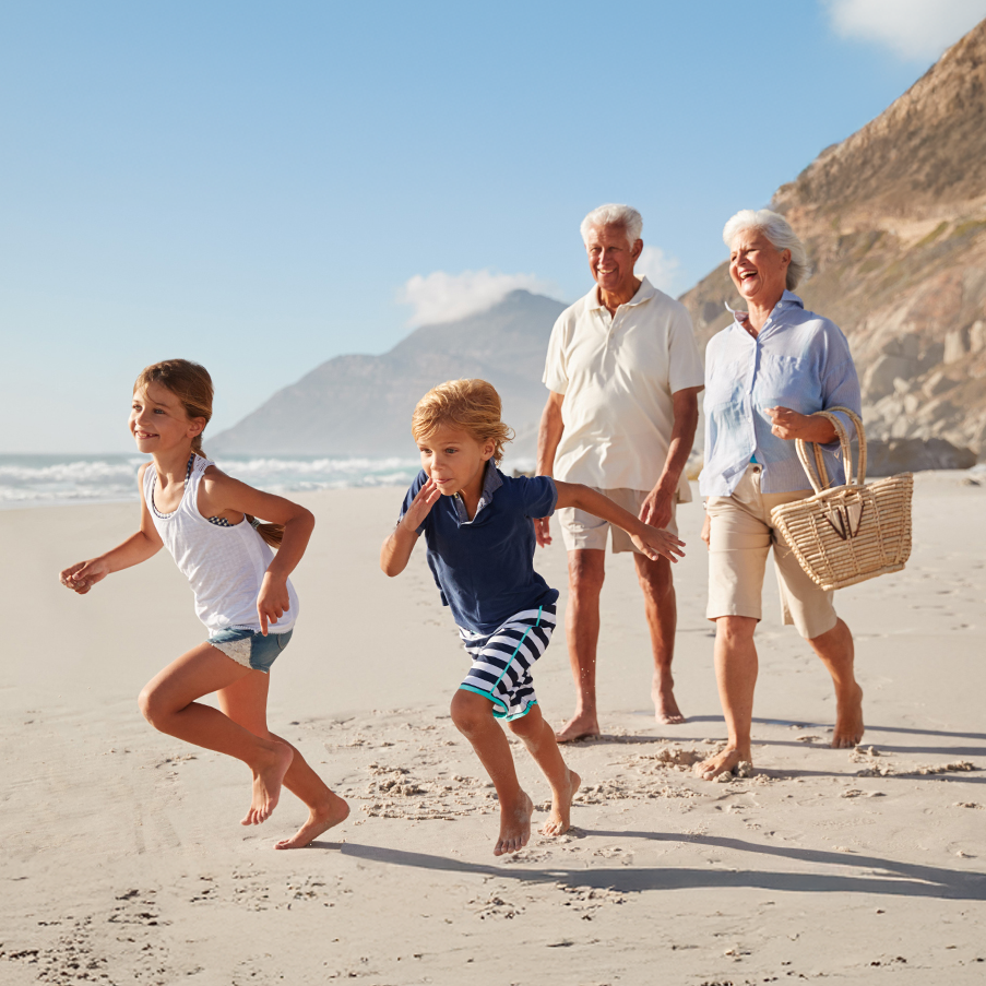 Grands-parents et petits-enfants se promenant sur la plage